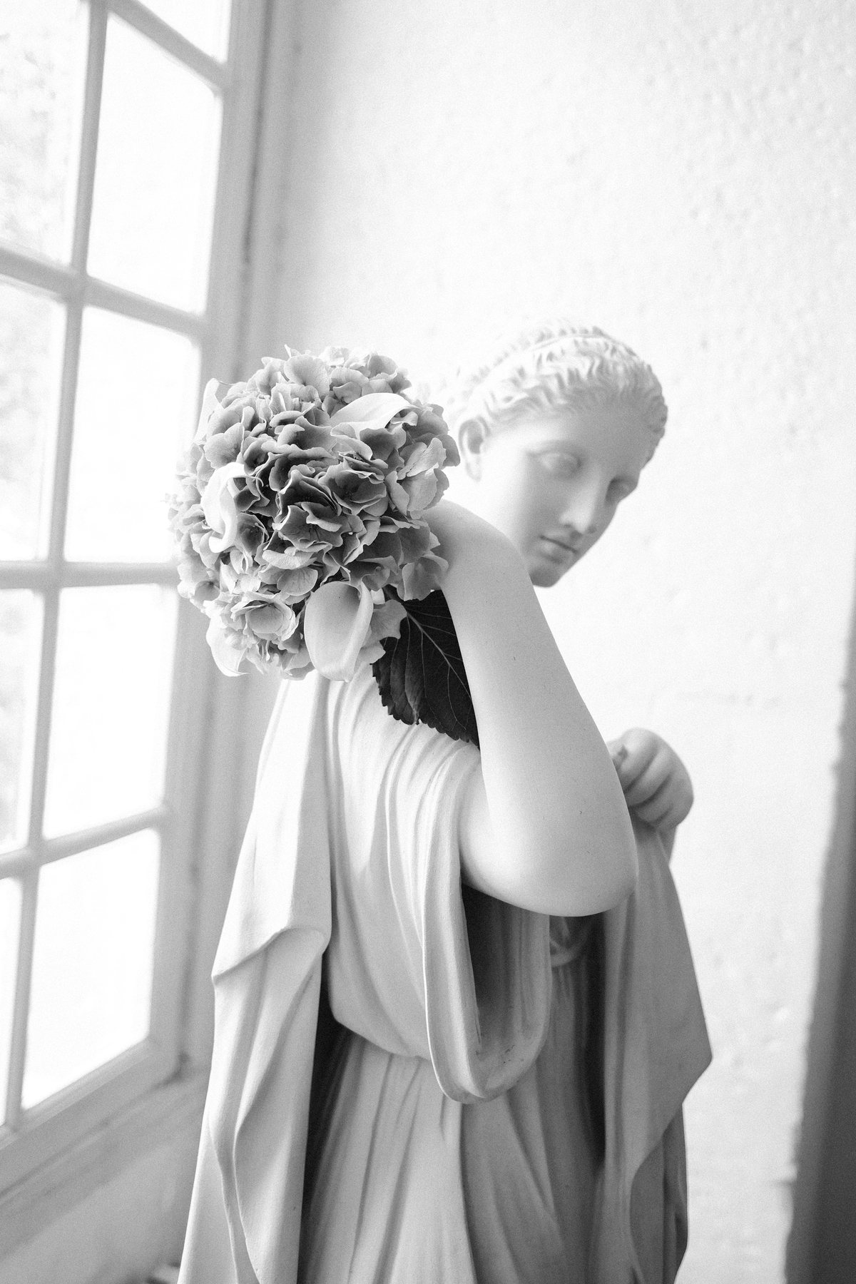Bouquet d'hortensias pos&eacute; sur une statue