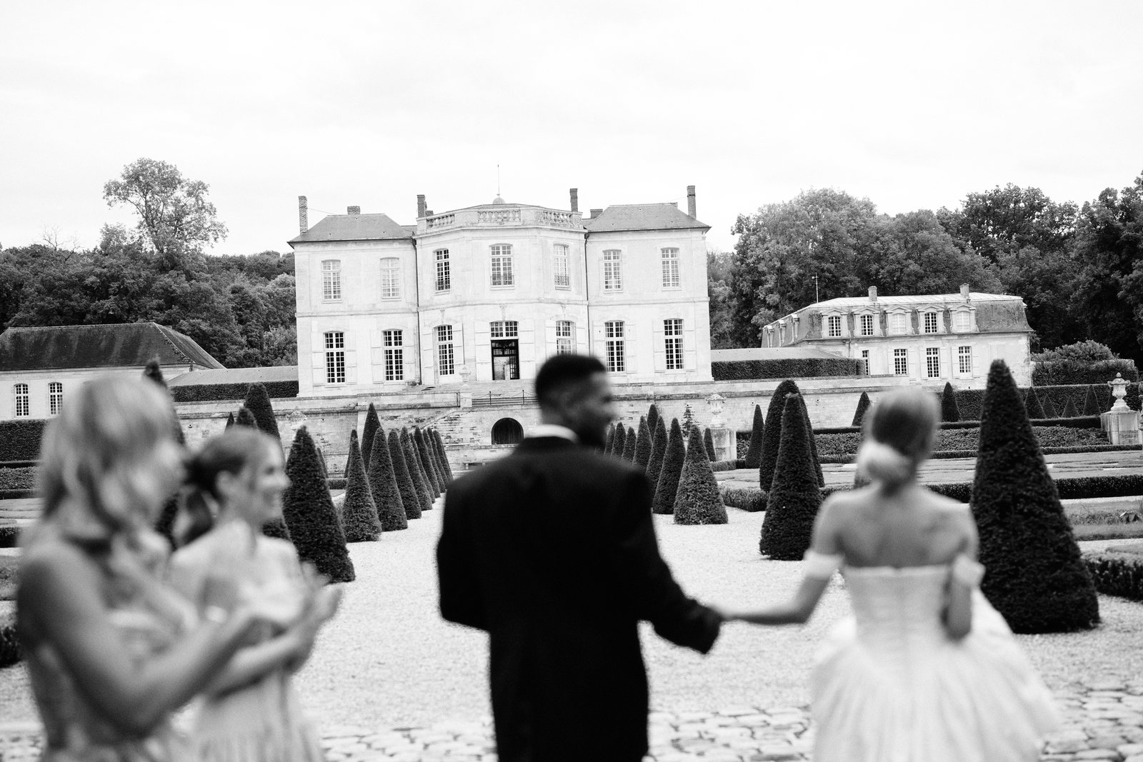 Les mari&eacute;s et leurs invit&eacute;s dans le jardin du ch&acirc;teau