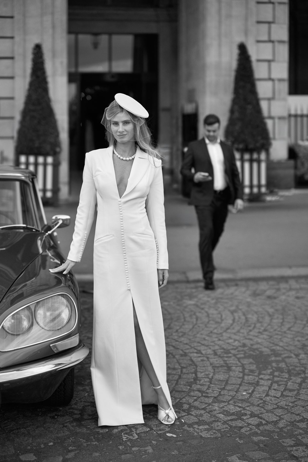 Mari&eacute;e en manteau blanc devant une voiture ancienne