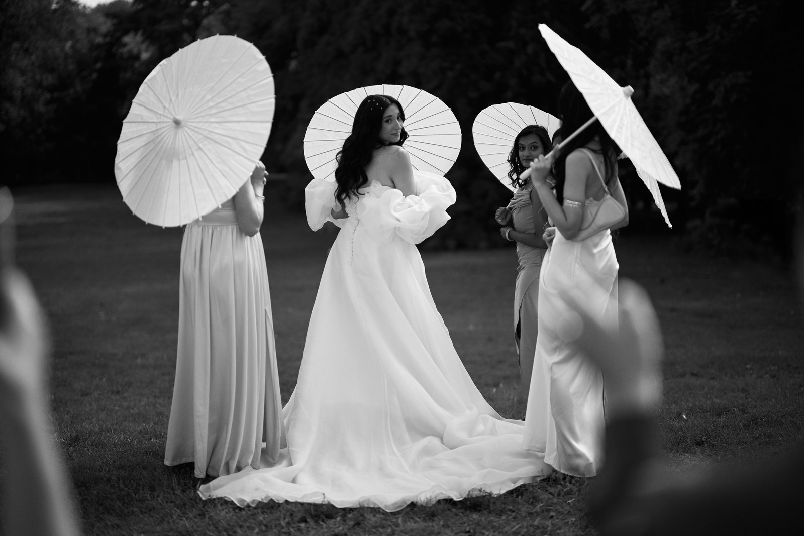 La mariée et ses témoins sous des ombrelles, dans le parc
